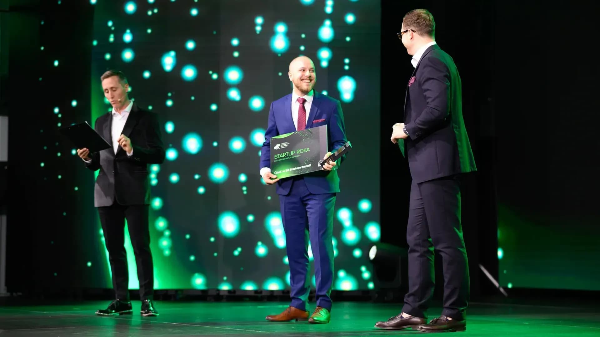 OWASmooth founder Miro holding a green award after winning the SISA on a modern green background